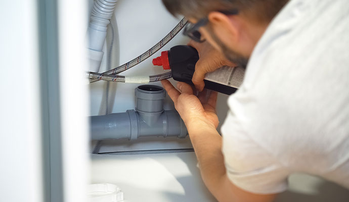 Man sealing pvc drain pipe joint