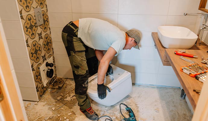 An expert installing a new toilet during a bathroom renovation