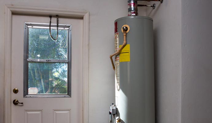A residential tank-style water heater installed in a utility room
