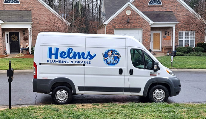 Helms Plumbing and Drains service van parked in a residential neighborhood