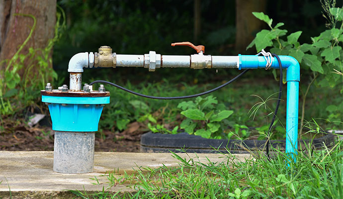 Outdoor well pump casing and pipe on concrete pad