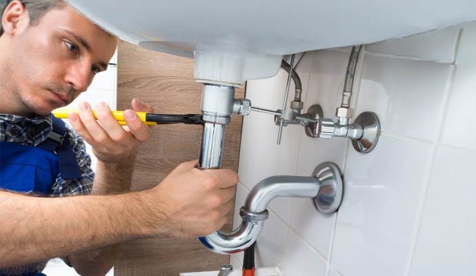 Plumber fixing leaky pipe