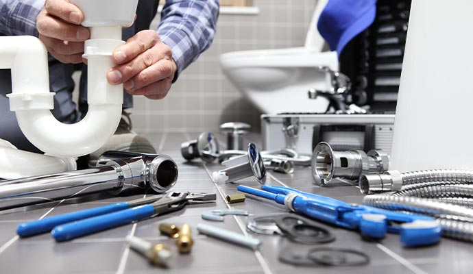 Plumber installing sink drain pipe