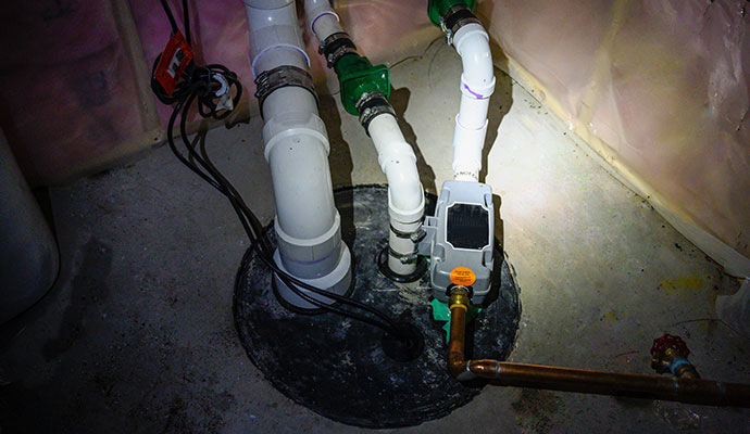Sealed sump pump basin with backup system and discharge pipes