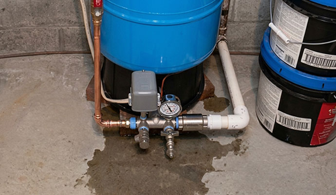 Water leaking from a well pressure tank on concrete floor